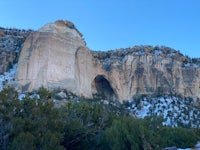 a large rock formation with snow on the ground