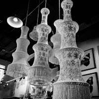 a black and white photo of several chandeliers hanging in a store