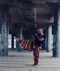a man doing a karate kick in the sand