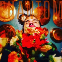 a man holding a bouquet of flowers in front of a wall