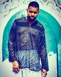 a man in a black shirt standing next to a fountain