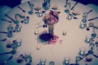 a round table with a vase of flowers and silverware