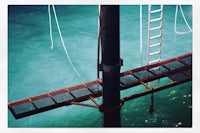 a ladder on a pier next to the water